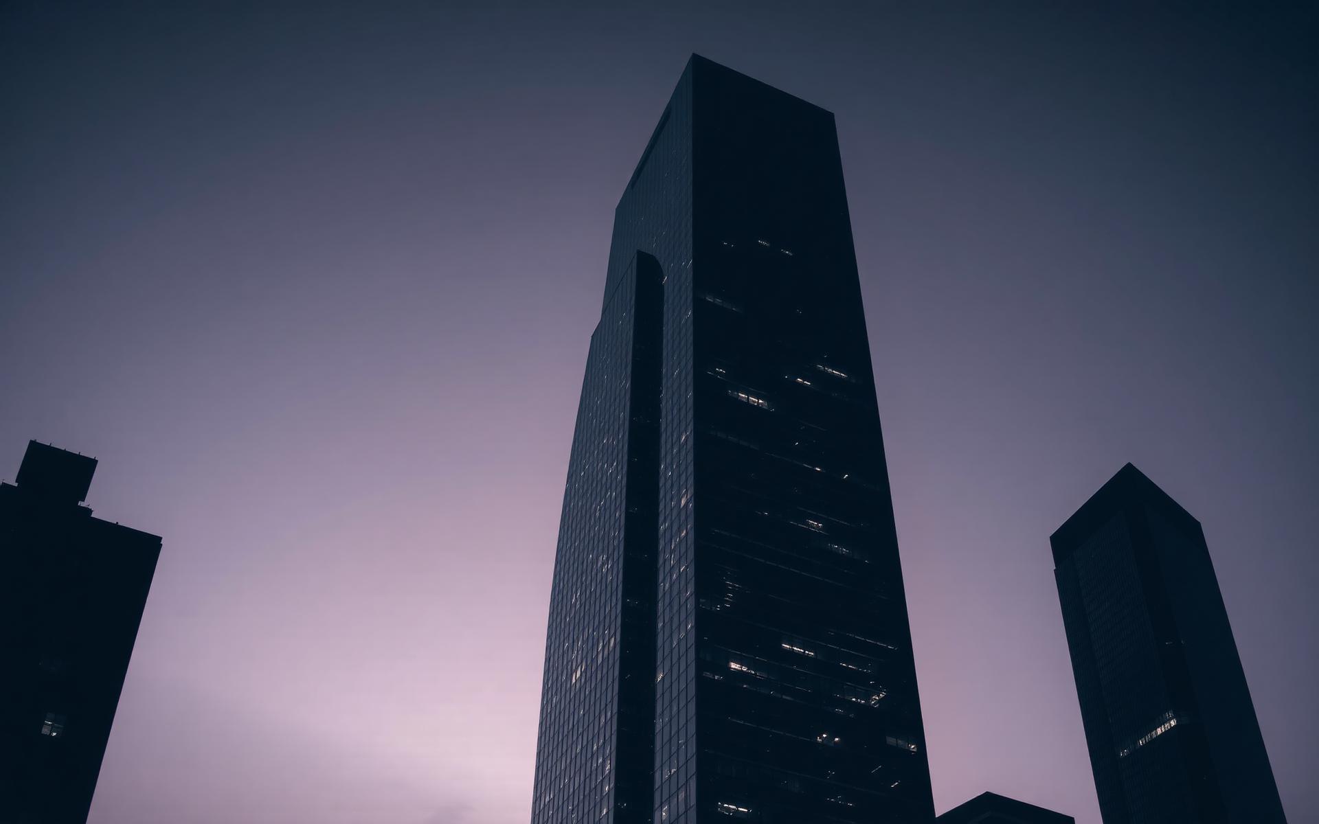 Torre corporativa de vidrio al anochecer